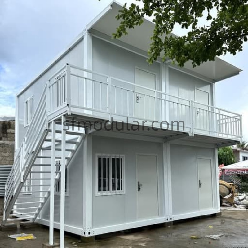 Front right exterior view of a two story container home with balcony and stairs