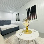 Bedroom interior of a modular container home with bed and small table