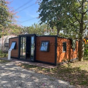 Exterior view of a luxury 20ft expandable container house with wood-grain wall panels installed in a scenic outdoor setting.
