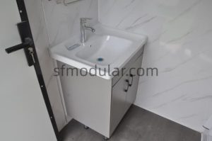 Ceramic vanity basin inside portable toilet with shower