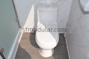 Ceramic toilet inside portable toilet with shower unit