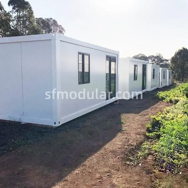 White prefabricated shelter exterior with windows on an outdoor project site