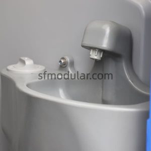 Close-up of hand wash sink inside a portable toilet for events