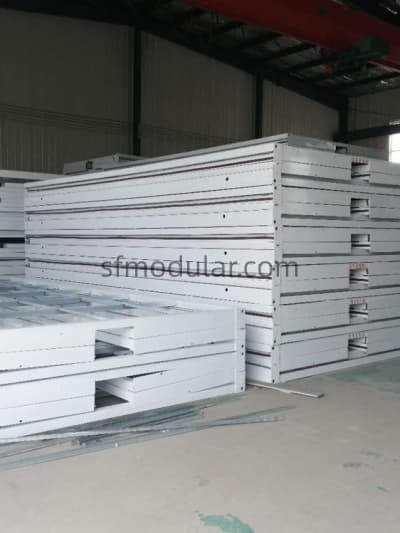 Foldable container house units stacked in flat pack form inside factory ready for shipment