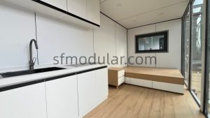 Close-up of functional kitchen cabinets and sink inside a prefabricated apple cabin pod