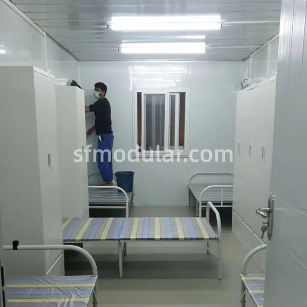 Comfortable temporary housing for construction workers dormitory interior with single beds and storage lockers in a portable prefab unit.