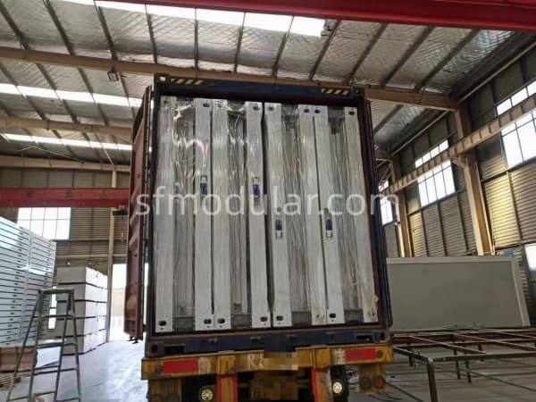 Loading flat pack container house components into a shipping container for export