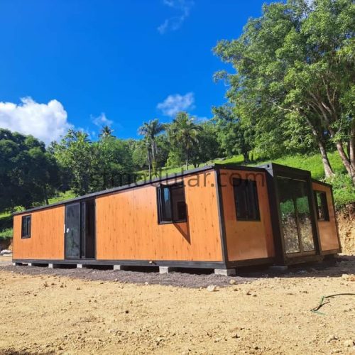 Spacious interior view of SUNFINE 40ft expandable container home showing wood-grain flooring, multiple room doorways, and energy-efficient LED ceiling lights.